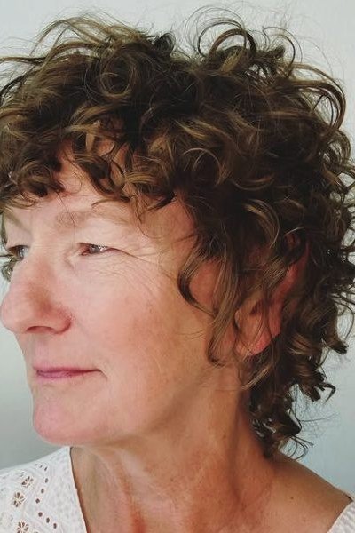 Brown Curly Pixie with Bangs curly bangs hairstyle for women over 60