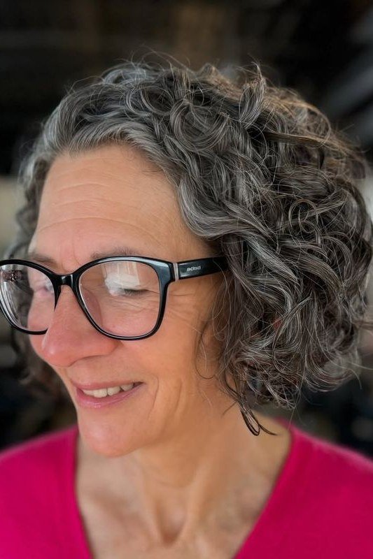 Gray Curly Bob with Bangs and Glasses curly bangs hairstyle for women over 60