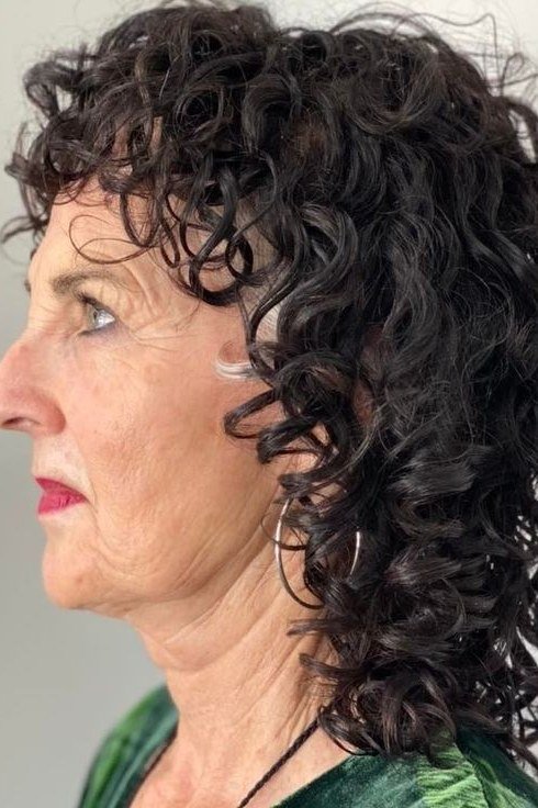 Long Dark Curls with Side-Swept Bangs curly bangs hairstyle for women over 60