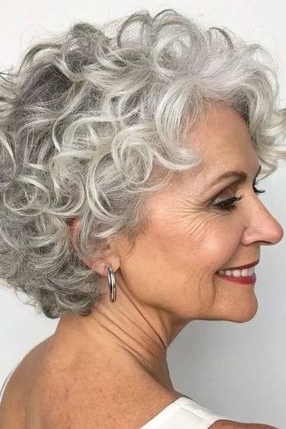 Silver tapered curly crop on a woman over 60, side view