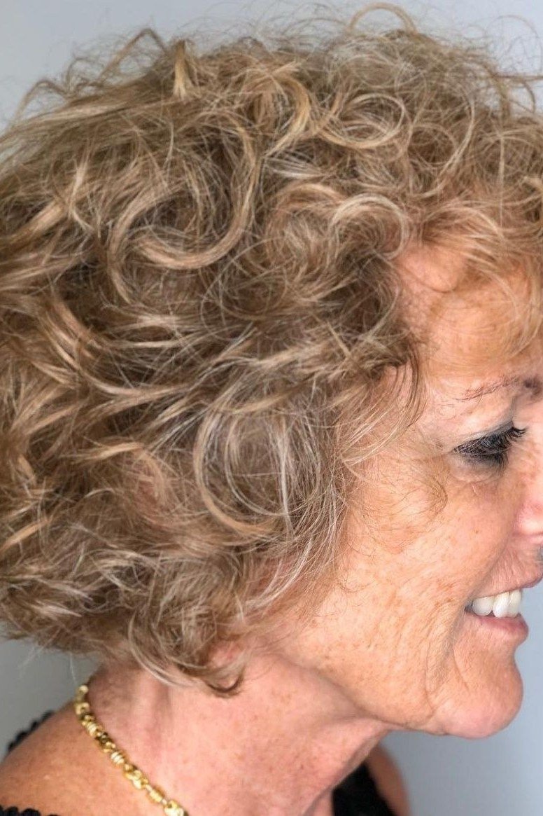 Loose blonde curly bob hairstyle for women over 60, side view
