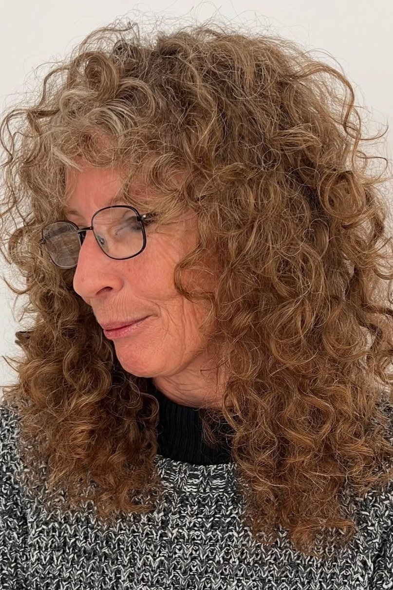 Auburn curly lob for women over 60 worn with glasses