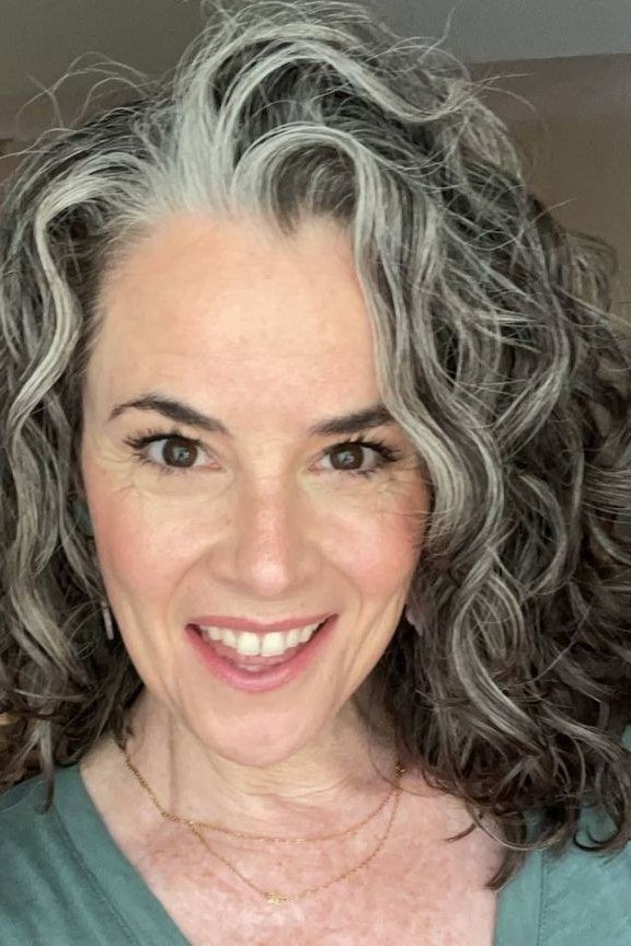 Full dark gray curly lob hairstyle for women over 60, front view