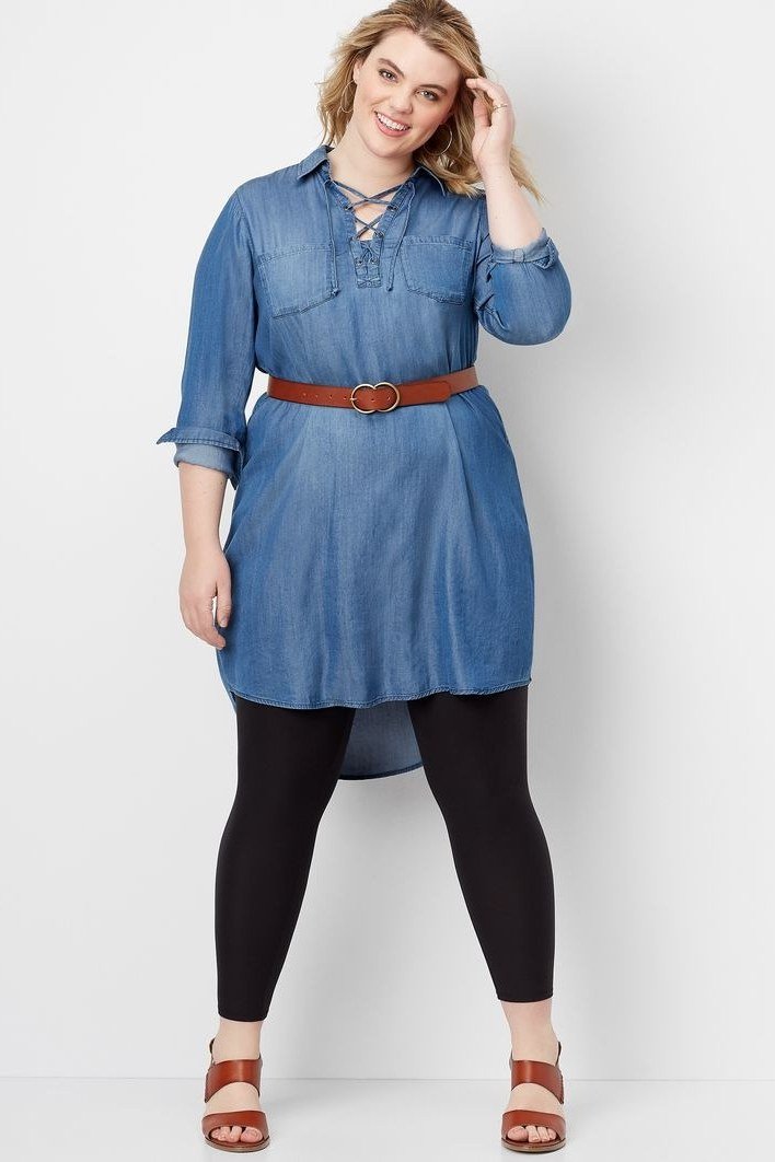 Curvy woman in chambray tunic dress with brown belt over black leggings, studio - denim dresses for women over 60