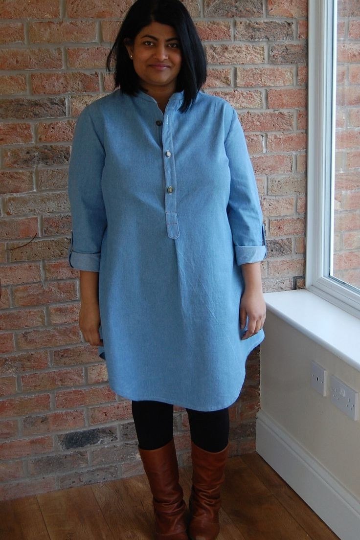 Woman in light chambray shirt dress with brown boots, by brick window - denim dresses for women over 60