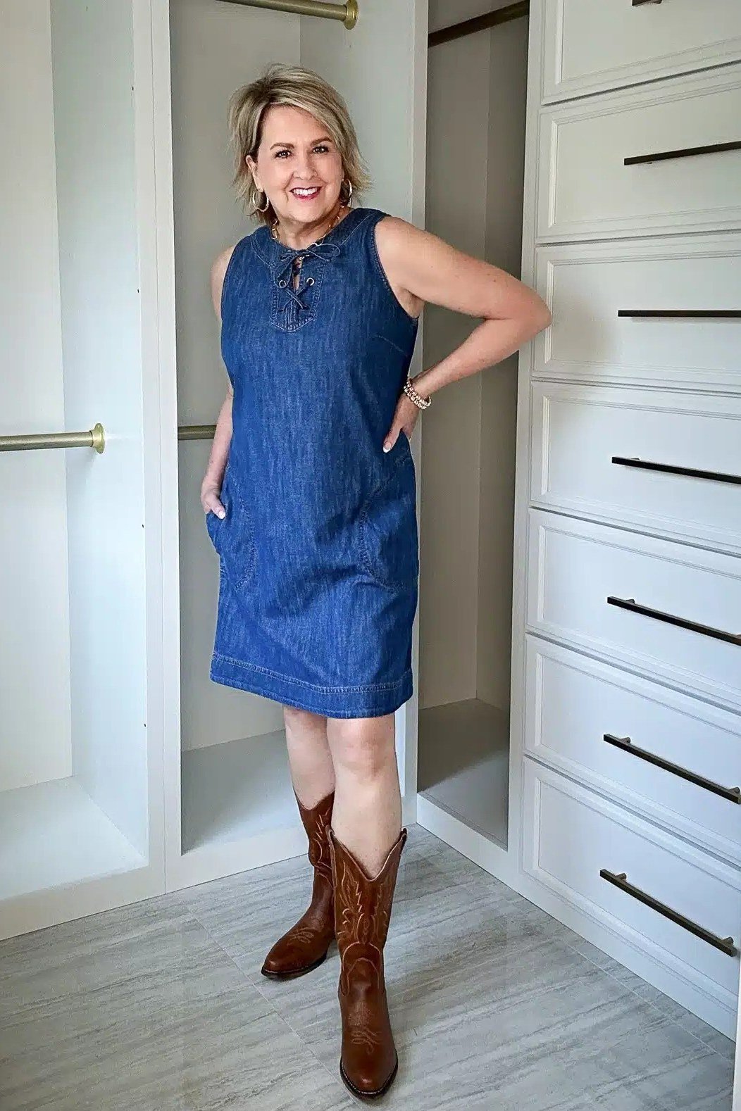 Blonde woman in denim mini shirt dress with cowboy boots, home interior - denim dresses for women over 60