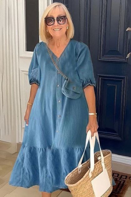 Blonde woman in chambray tiered midi dress with straw tote, doorway - denim dresses for women over 60