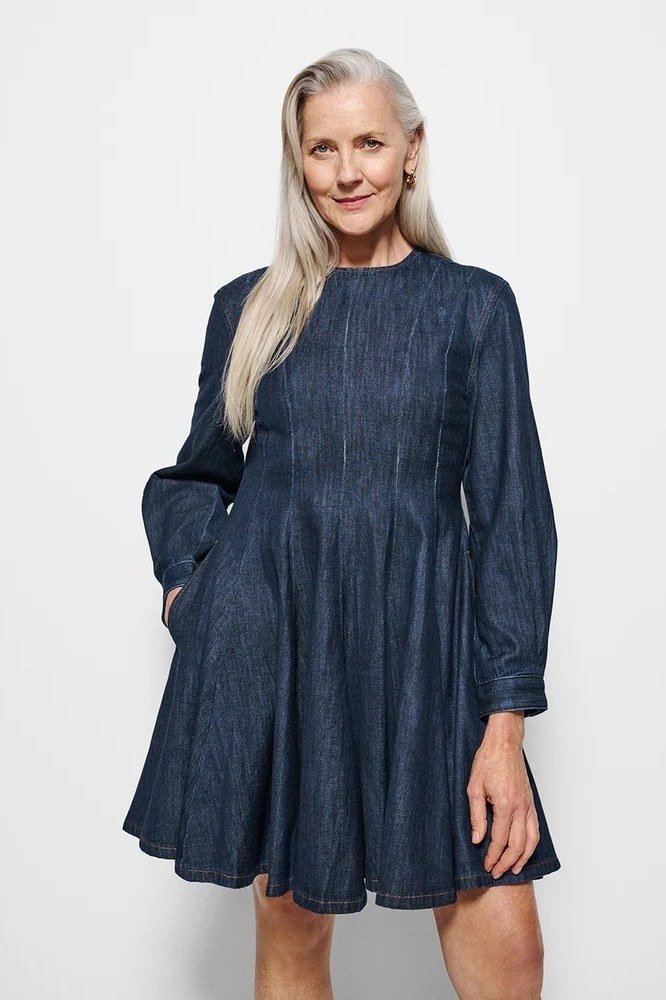 Grey-haired woman in dark denim skater dress, studio - denim dresses for women over 60