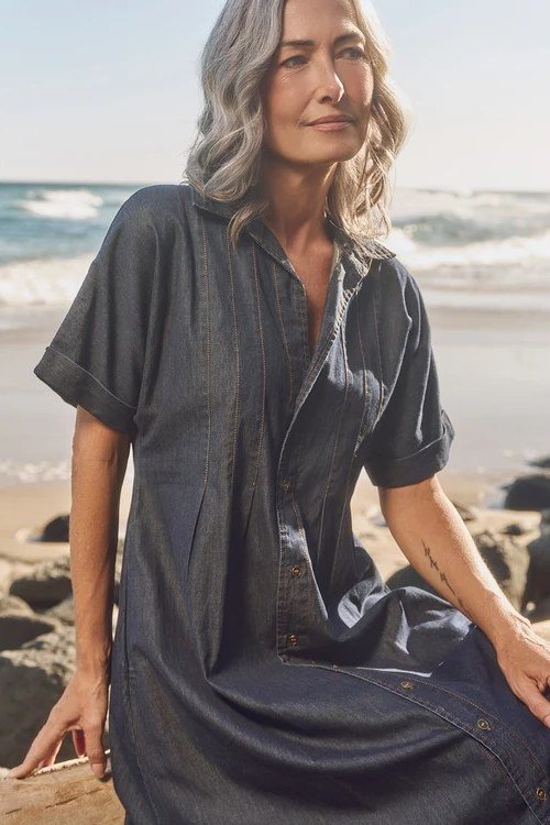 Woman in dark denim shirt dress on beach - denim dresses for women over 60