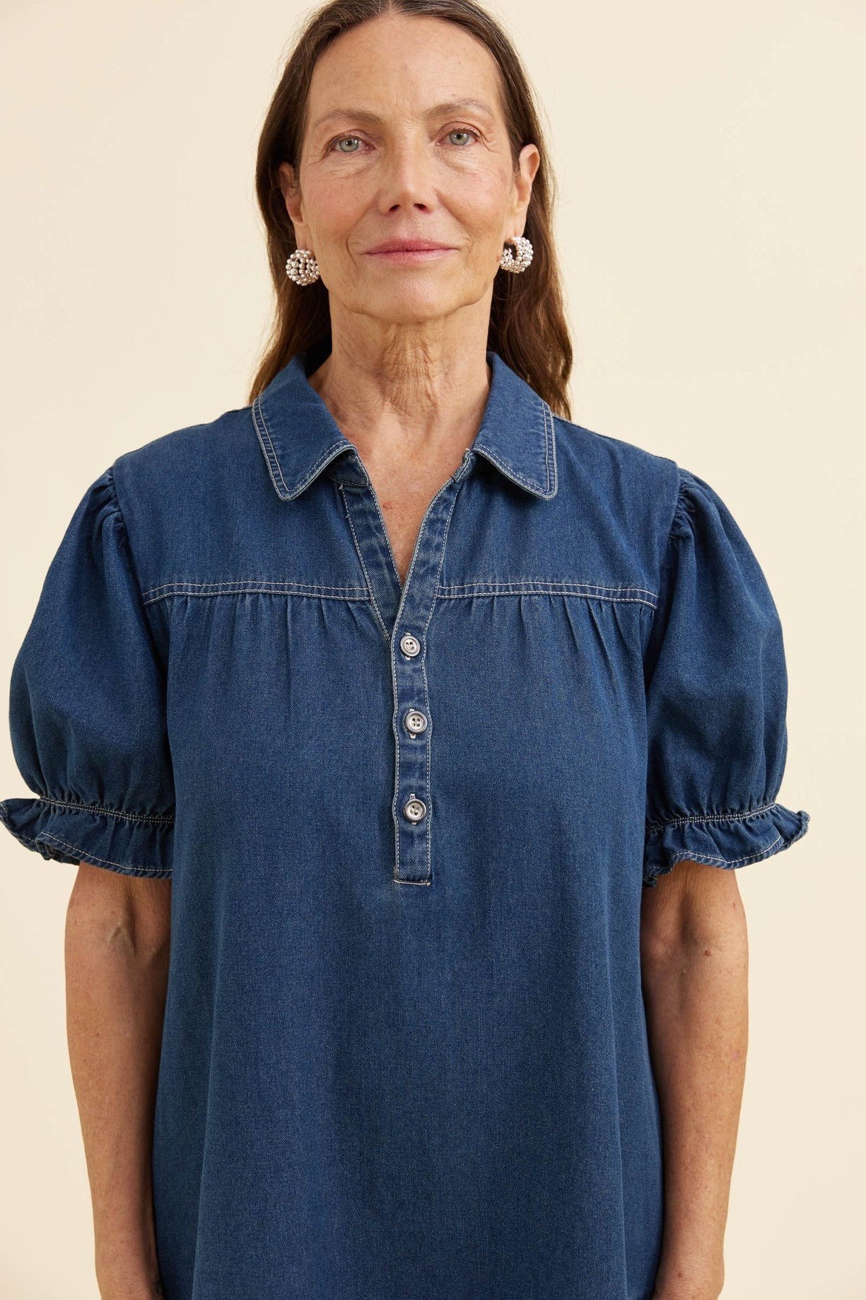 Woman in dark denim puff-sleeve shirt dress, studio - denim dresses for women over 60