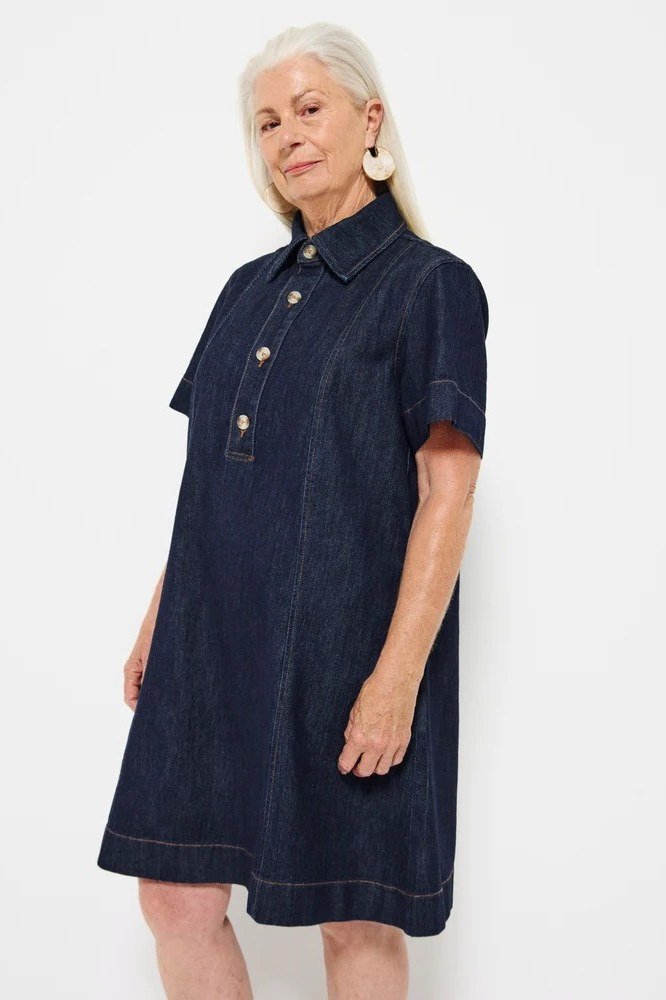 White-haired older woman in dark denim short shirt dress, studio - denim dresses for women over 60