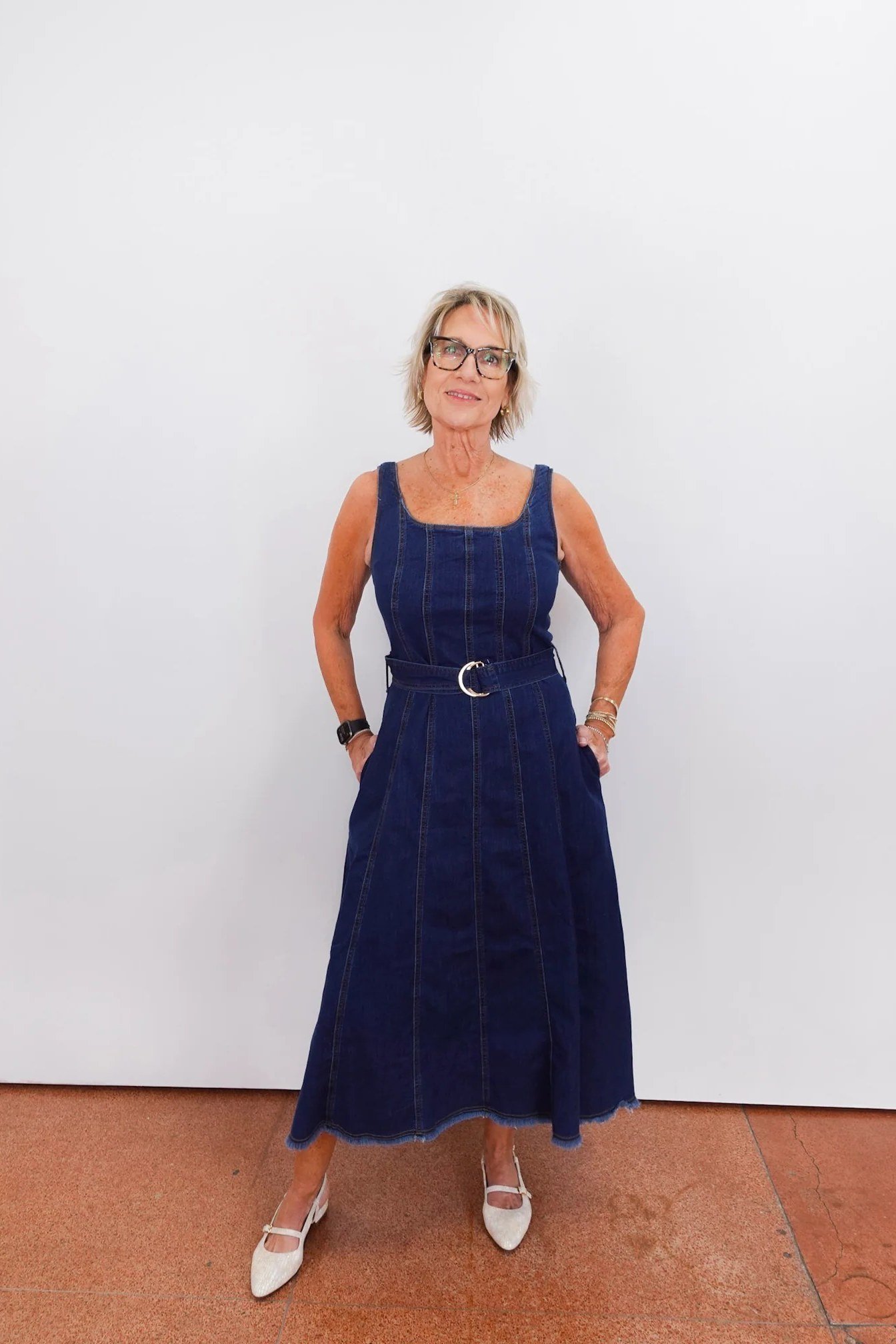 Woman in dark denim sleeveless midi dress with heels, studio - denim dresses for women over 60