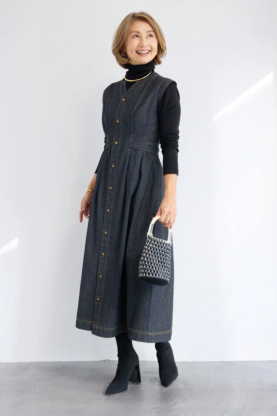 Woman in dark denim maxi shirt dress with black turtleneck and boots, studio - denim dresses for women over 60