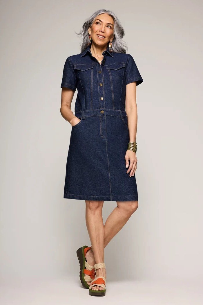 Grey-haired woman in dark denim short shirt dress with sandals, studio - denim dresses for women over 60