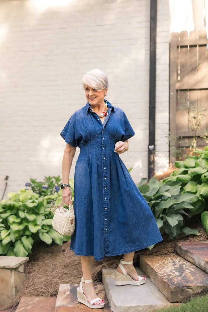 Mid-blue denim shirt dress, garden setting - denim outfit idea for women over 50