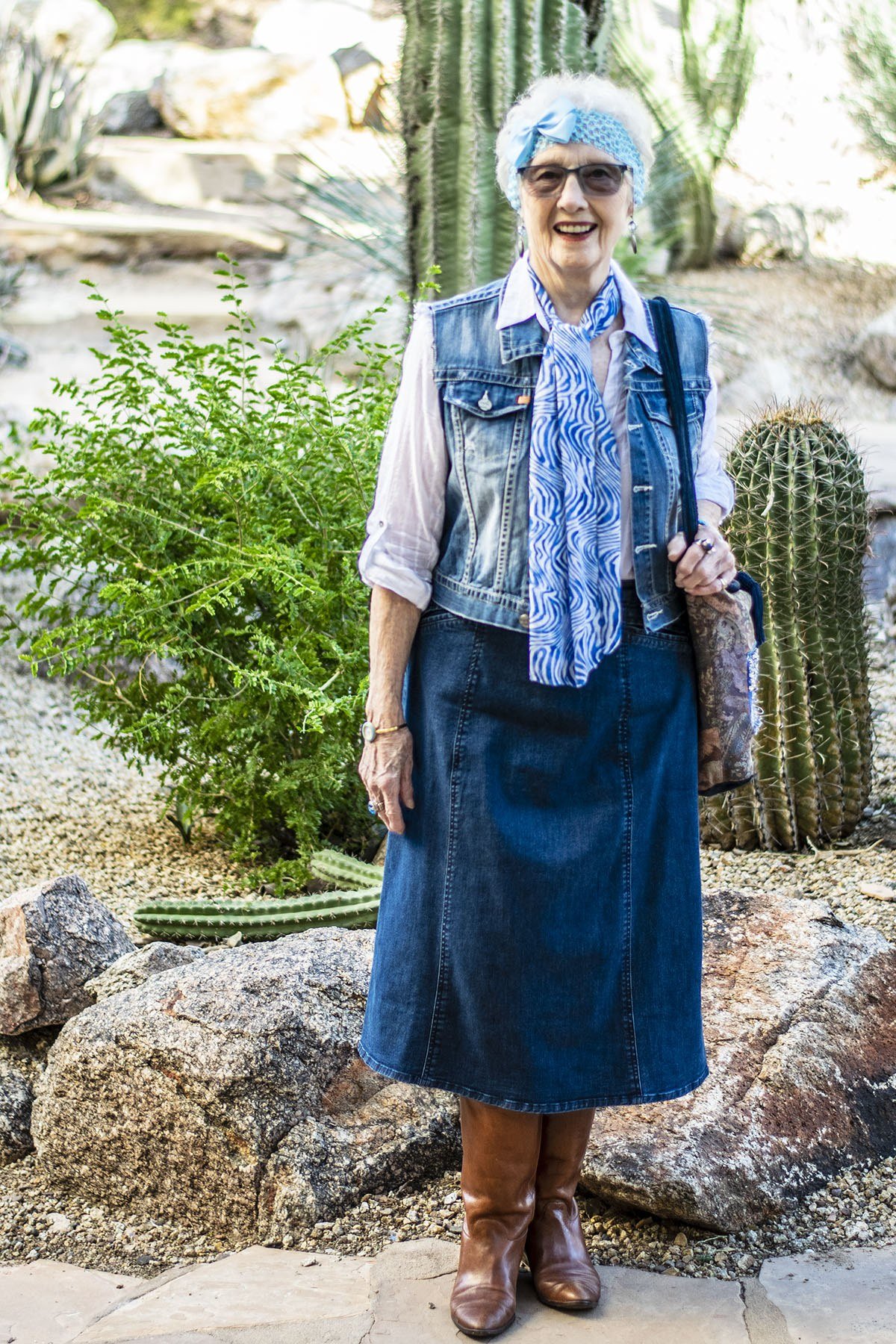 Denim vest, denim midi skirt, blue scarf, cactus garden, brown boots - denim outfit idea for women over 50