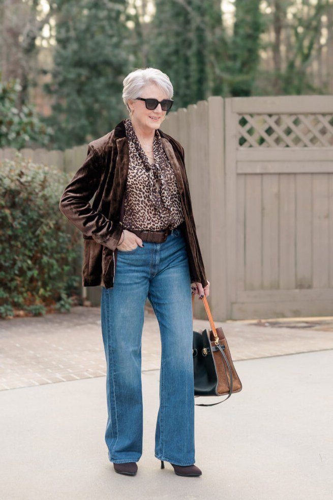 Brown velvet jacket, leopard top, medium jeans, outdoors - denim outfit idea for women over 50