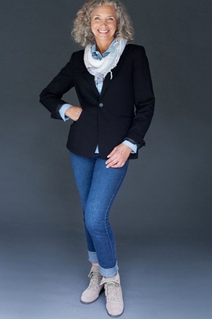 Black blazer, scarf, medium jeans, sneakers, studio - denim outfit idea for women over 50
