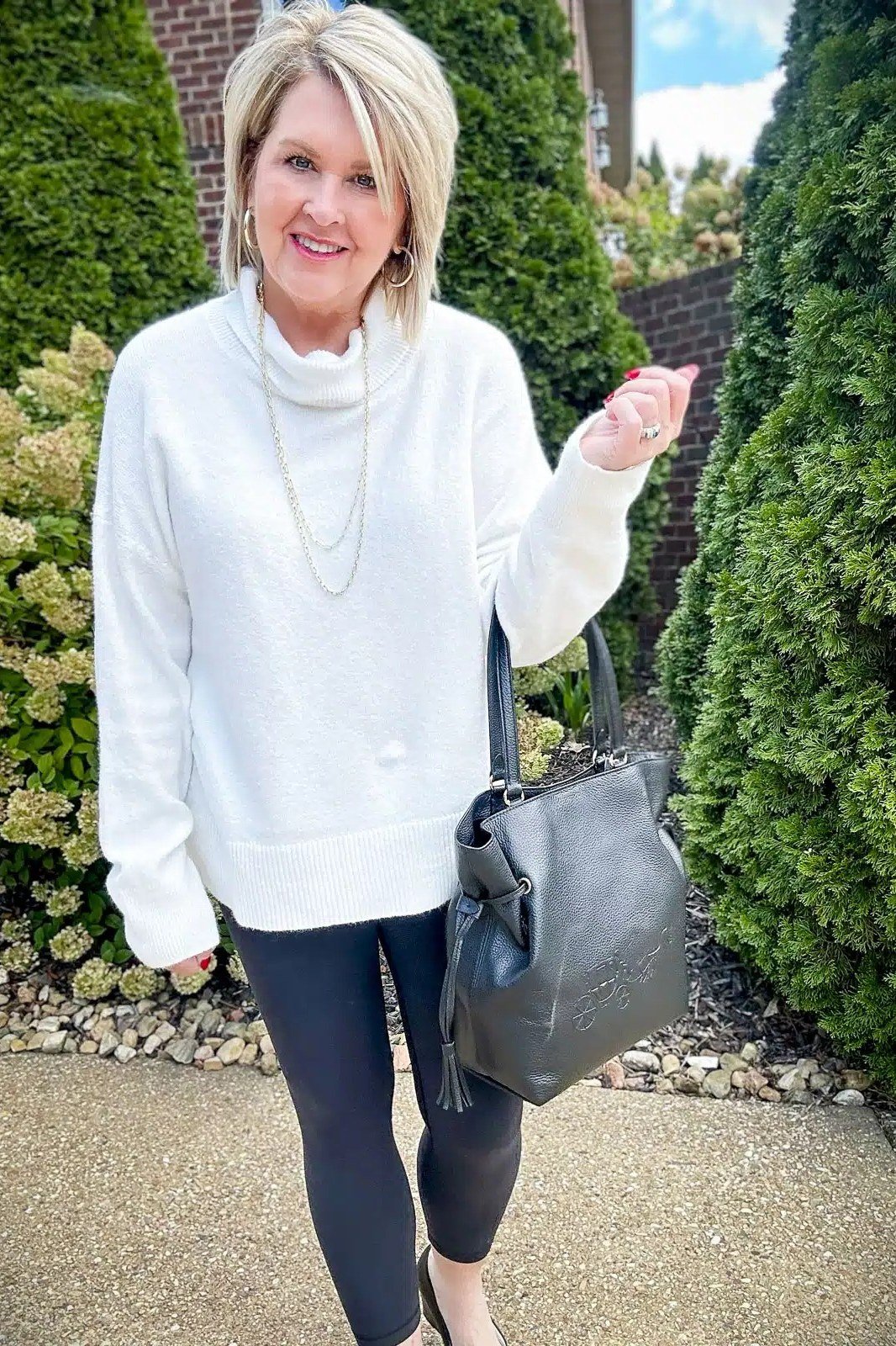 white turtleneck, navy wide-leg pants, outdoor hedge