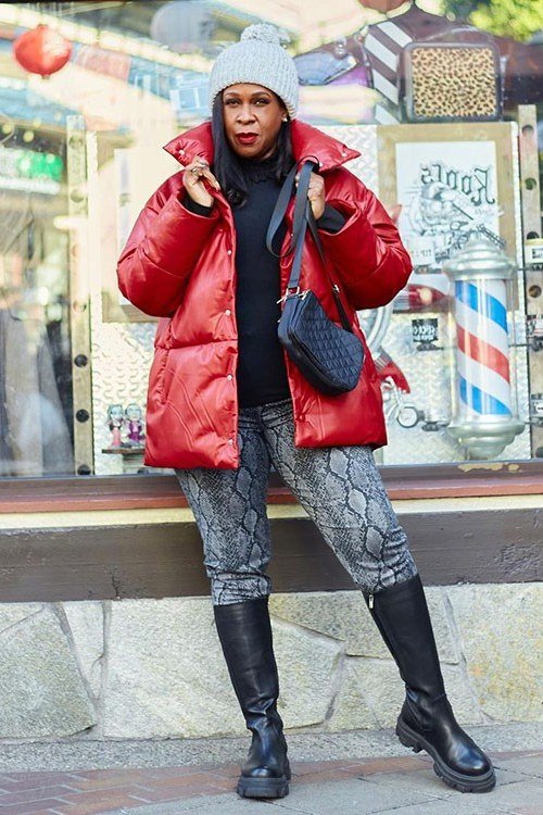 red puffer jacket, snake-print leggings, black boots