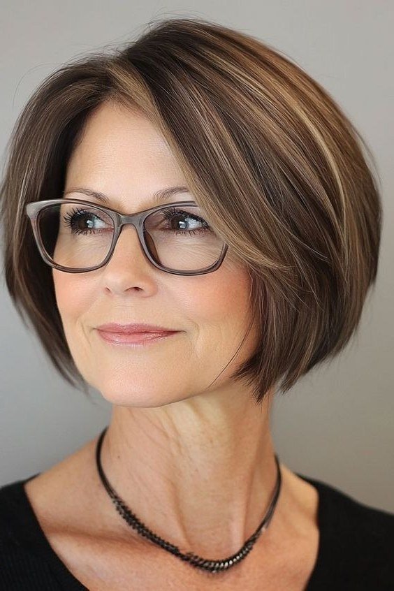 Highlighted brown layered bob with glasses for women over 50