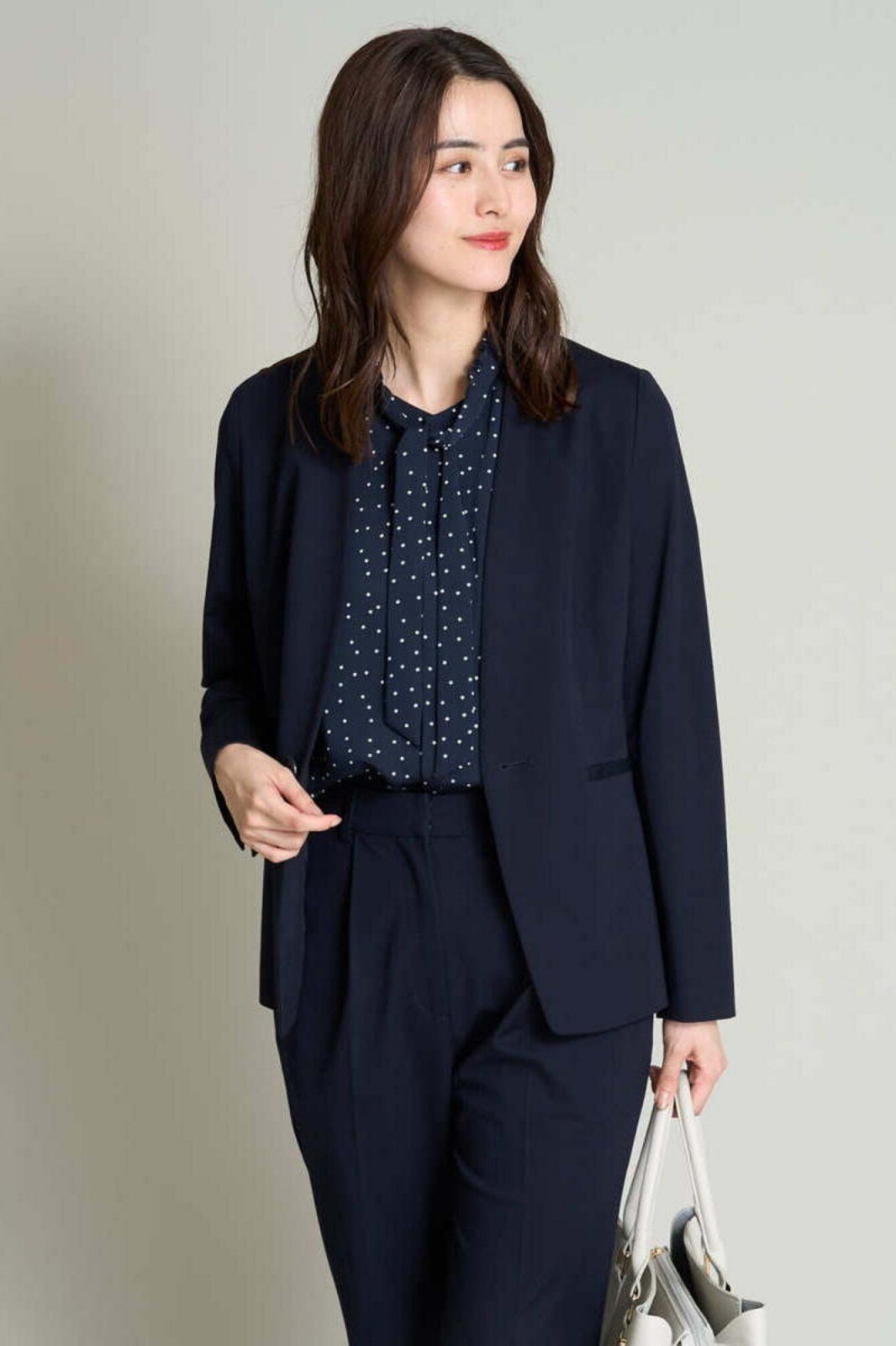 Navy blazer with polka-dot blouse and navy trousers for older women