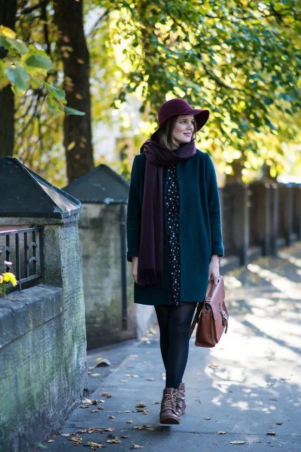 Teal coat with purple scarf and hat on a garden path for older women