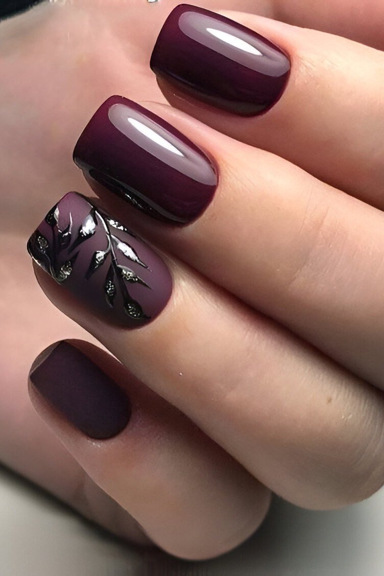 Dark plum nails with metallic leaf accent, elegant nail idea for women over 50