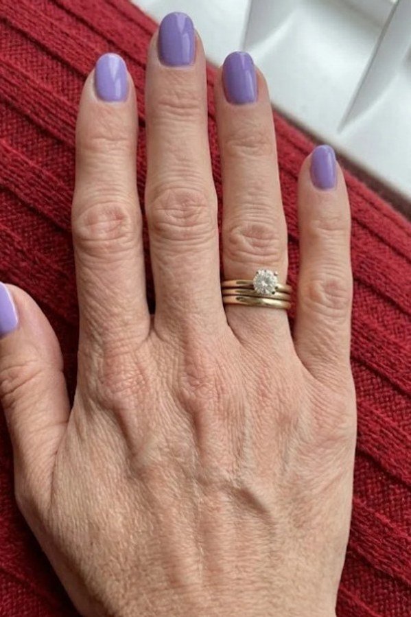 Lavender-mauve nails with gold rings, elegant nail idea for women over 50