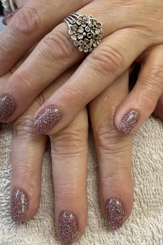 Mauve-pink glitter nails, elegant nail idea for women over 50