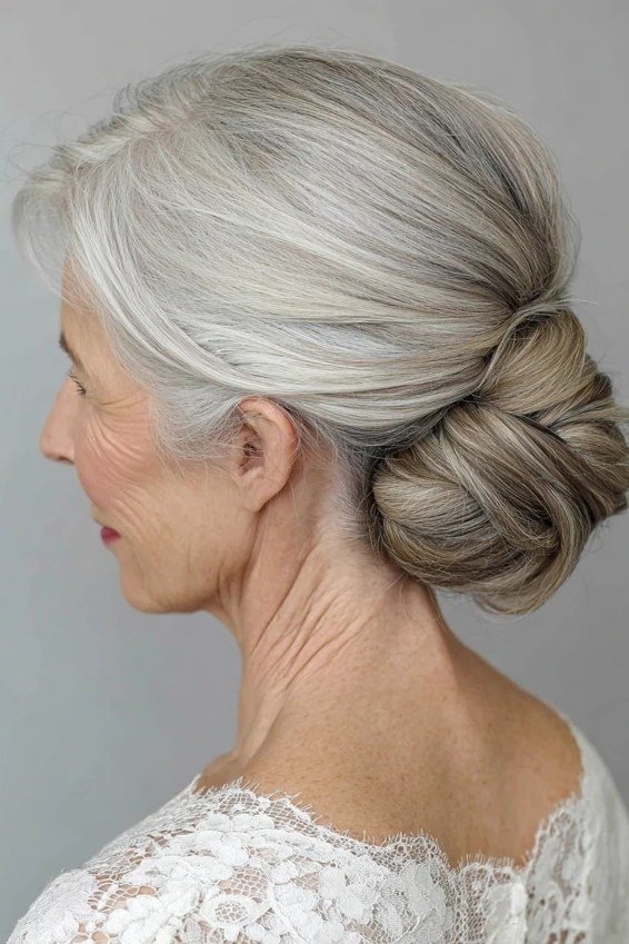 Low grey bun side view with white lace, an elegant updo for women over 70