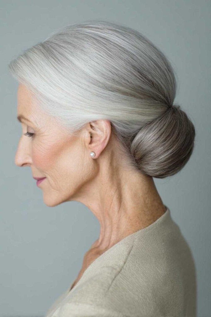 Smooth silver low bun in profile, an elegant updo for women over 70