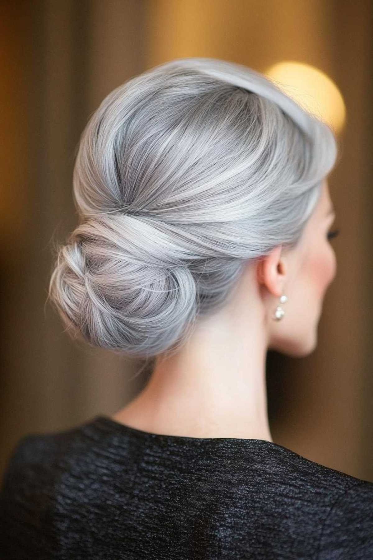 Silver low bun side view in warm light, an elegant updo for women over 70