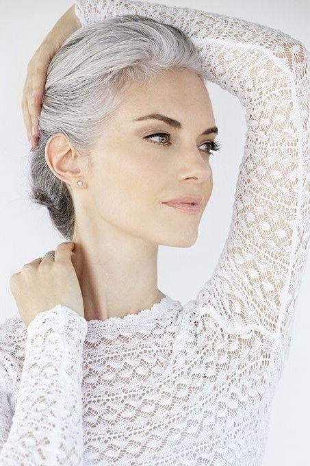 Silver updo three-quarter view in white lace top, an elegant updo for women over 70