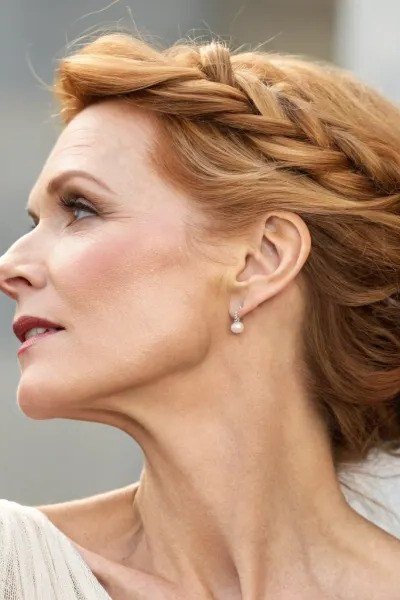 Blonde braided crown bun in profile, an elegant updo for women over 70