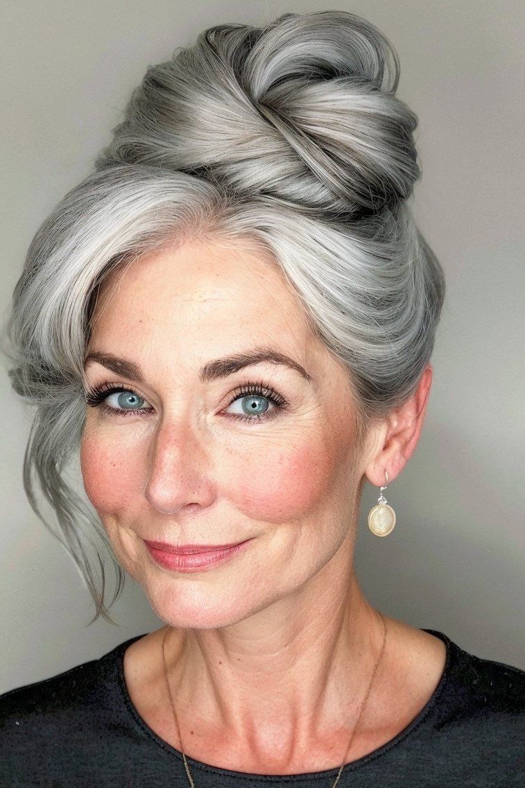 Silver top knot front view in dark top, an elegant updo for women over 70