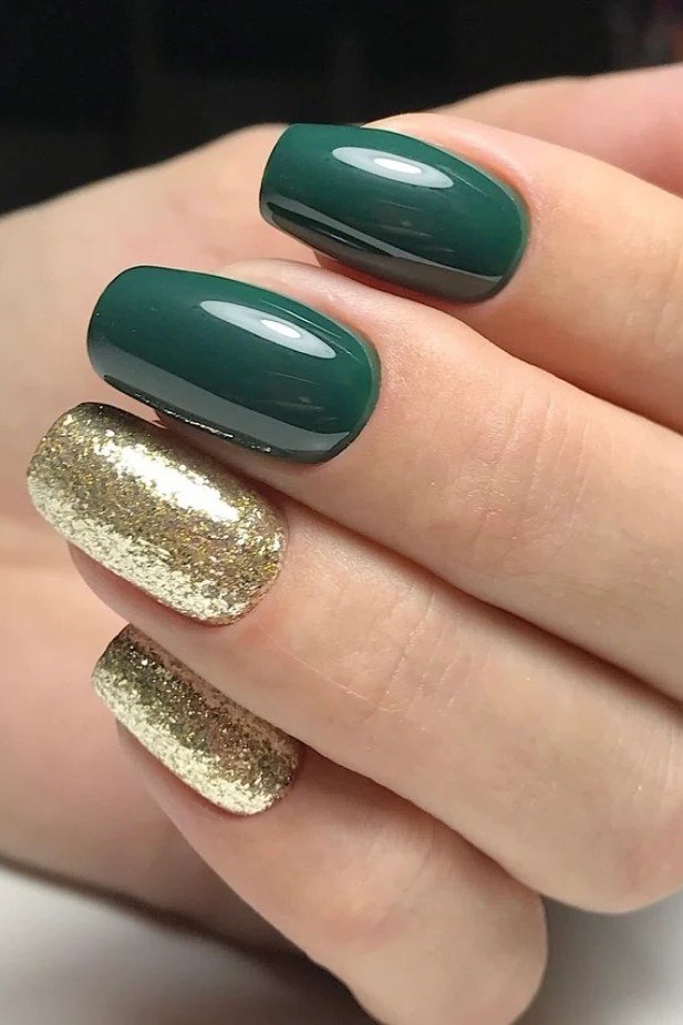 Glossy dark green nails with chunky gold glitter accents for women over 60