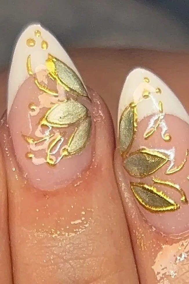 Sage green stiletto nails with gold leaf tips for women over 60