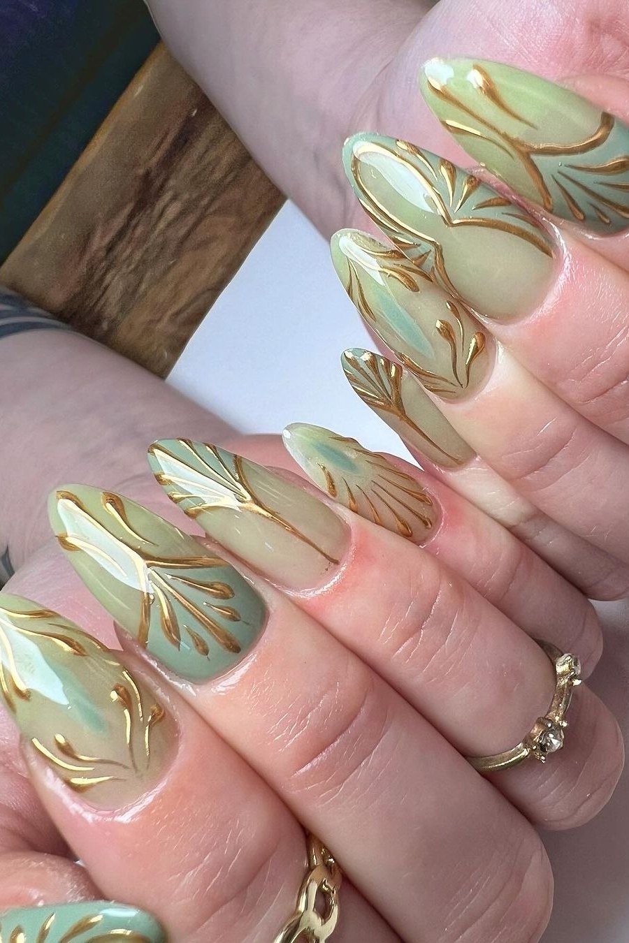 Sage green nails with gold line nail art for women over 60