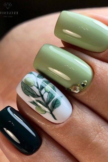 Sage green nails with leaf art and dark accent nail for women over 60