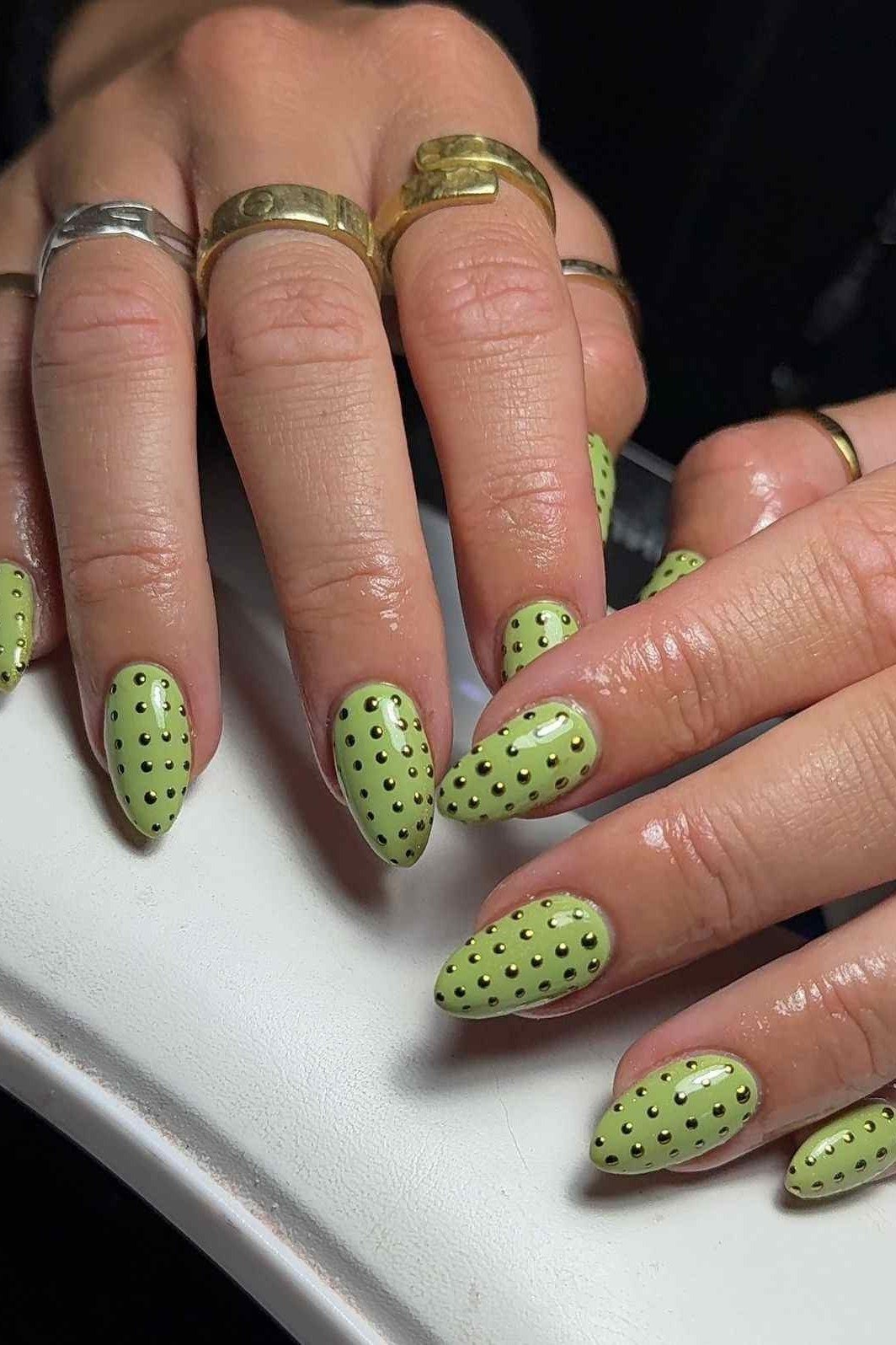 Light green nails with dark green dots and gold details for women over 60