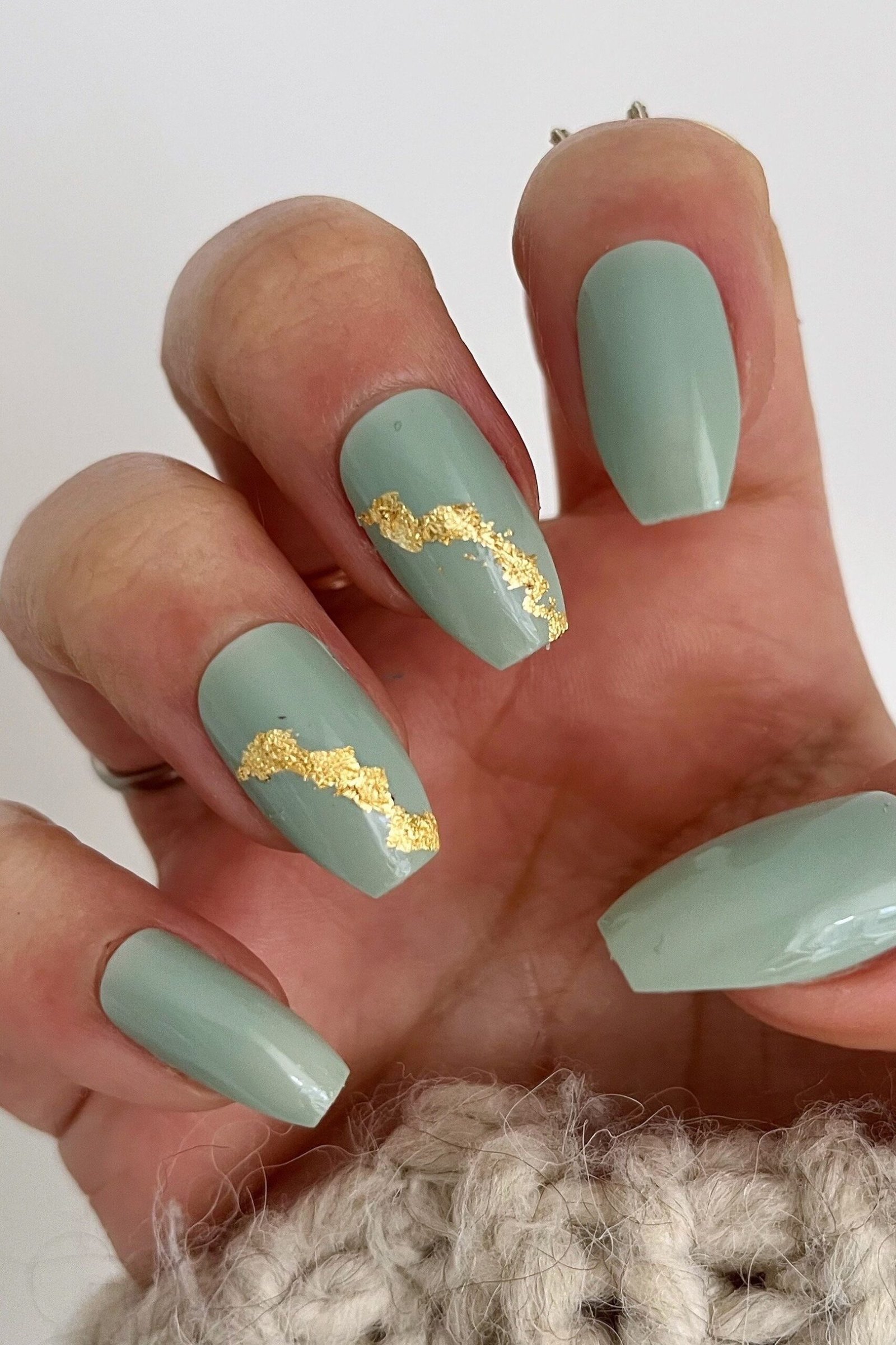 Mint green nails with gold foil accents for women over 60