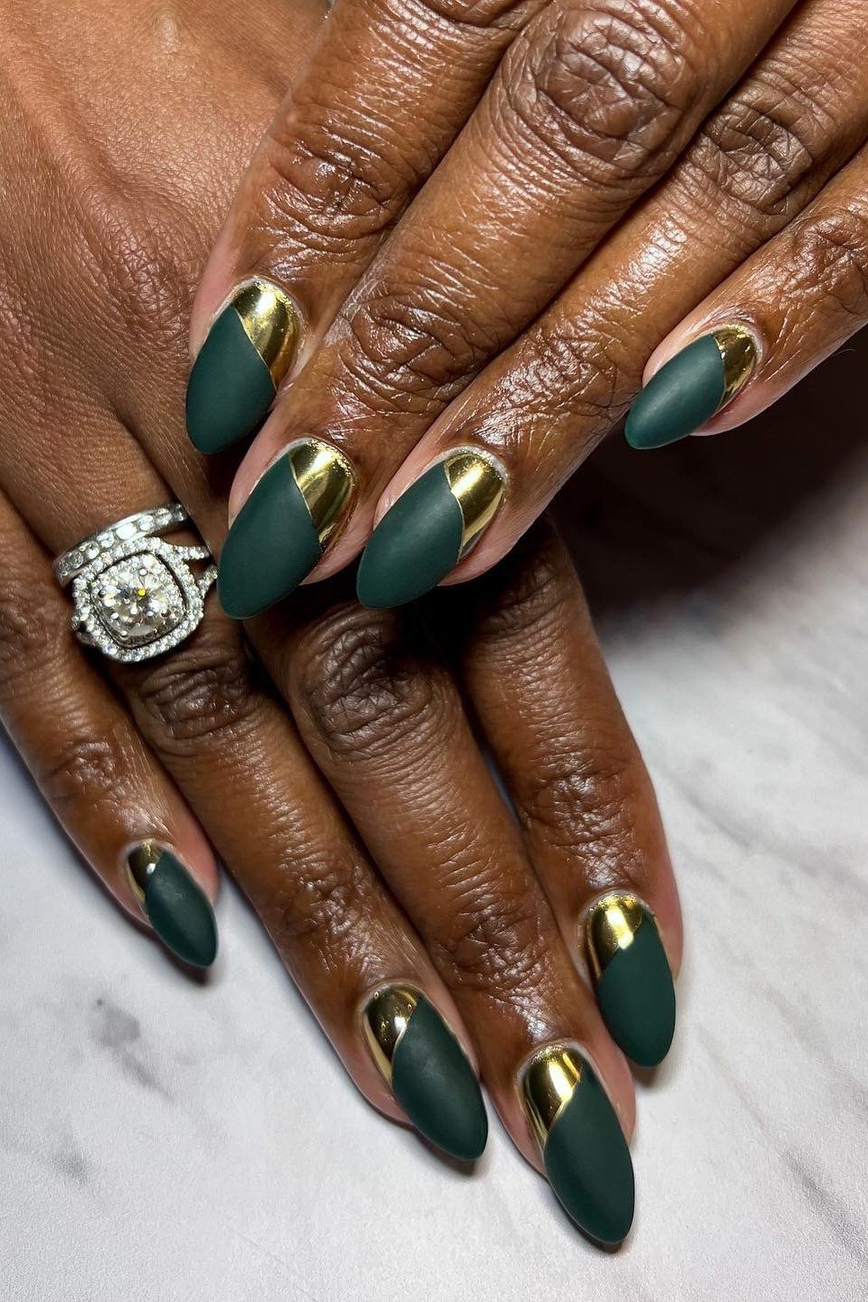 Dark green nails with gold tips on deep skin tone