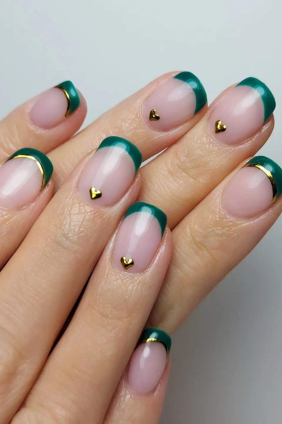Nude nails with green French tips and gold hearts for women over 60