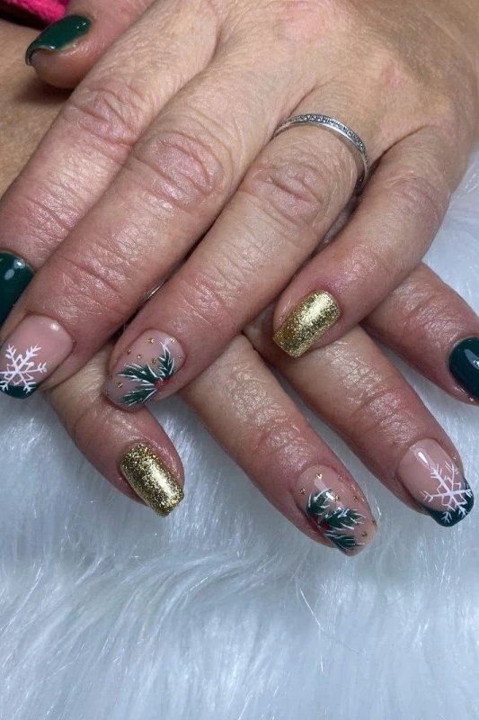 Dark green and gold nails on mature hands of a woman over 60