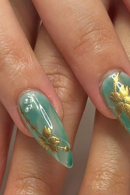 Green nails with gold leaf branch nail art for women over 60