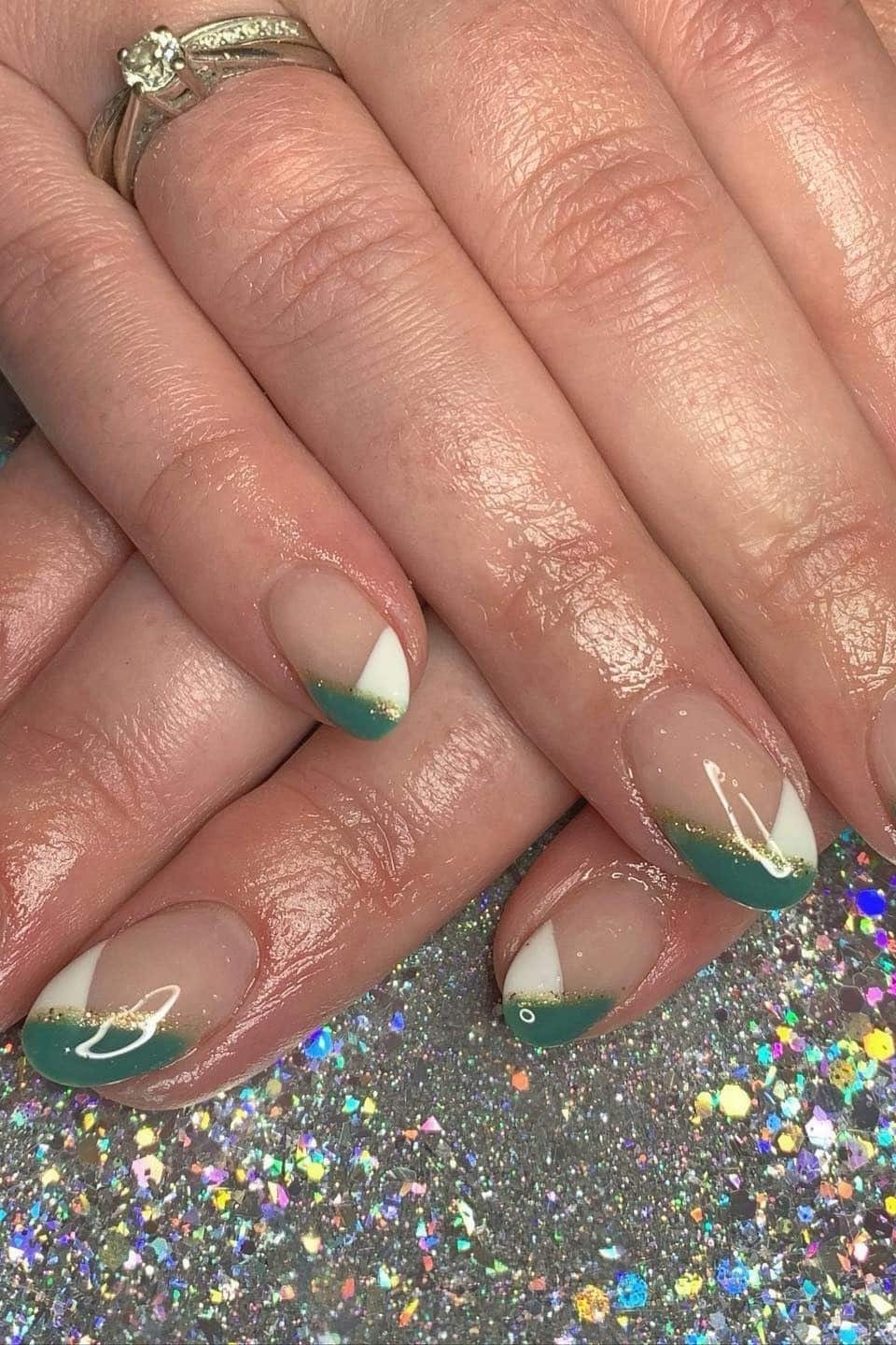 Nude nails with green French tips on mature hands of a woman over 60
