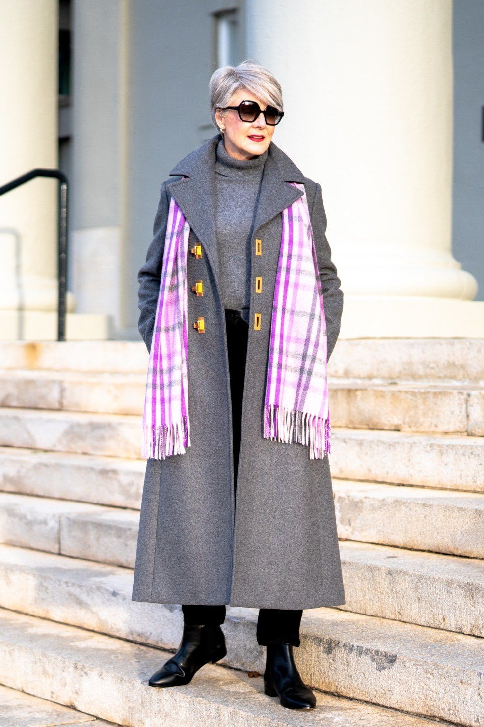 Grey Coat with Pink Plaid Scarf on Stone Steps, elegant winter outfit for women over 60