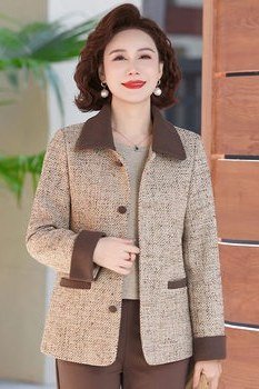 Elegant work outfit for women over 50: brown tweed jacket, brown suit, wooden wall, 3/4 view