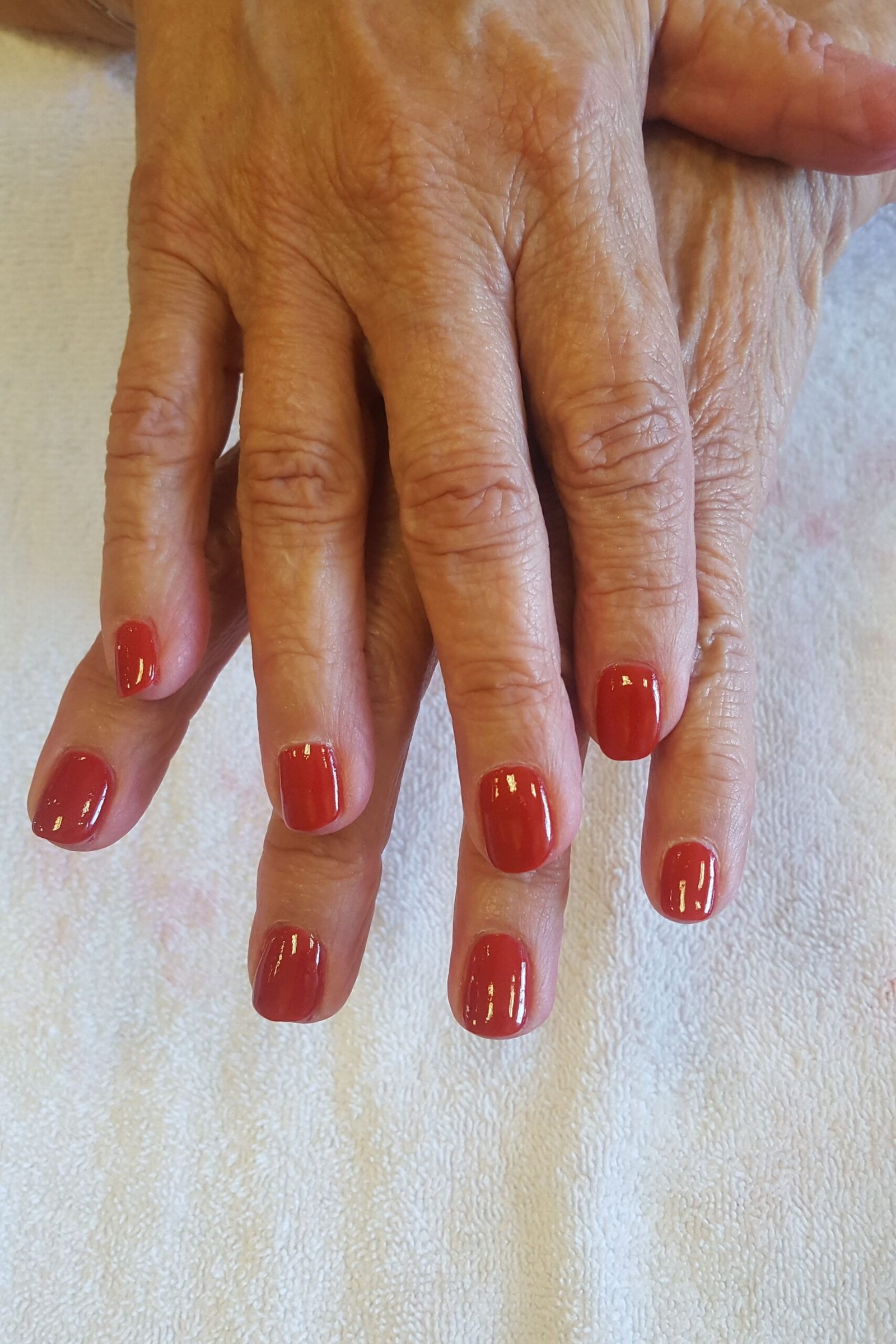 Warm Red Over a White Towel, elegant winter nail color idea for older women